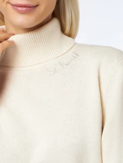 Frau hat einen weißen Rollkragenpullover gestrickt