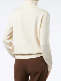 Frau hat einen weißen Rollkragenpullover gestrickt